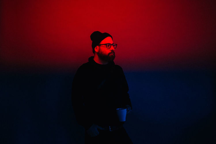 Copy Space Hat Looking Away Red Blue Coffee Cup Cool Attitude Eyeglasses Front View Hipster Leisure Activity Lifestyles Neon Neon Lights One Person Real People Red Color Standing Young Adult