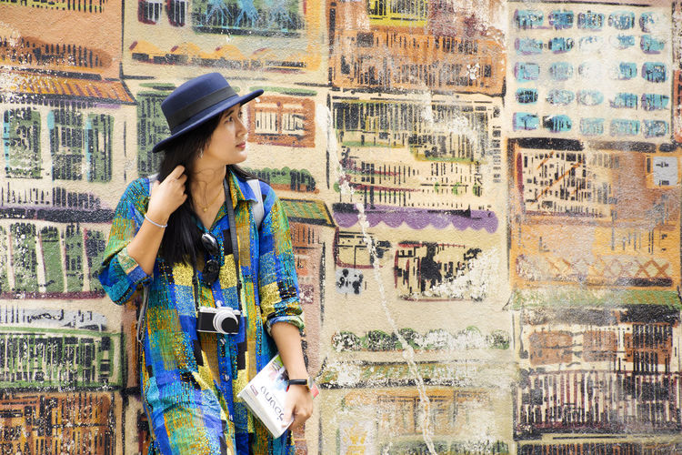 Woman standing against graffiti wall