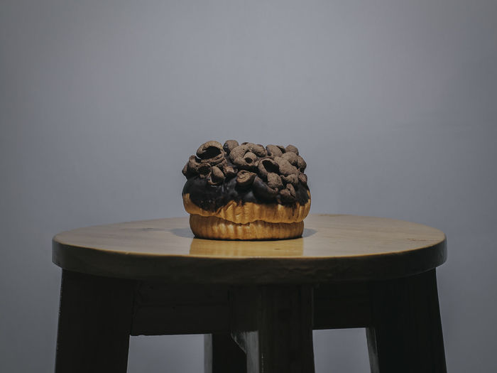 Close-up of cake on table against wall