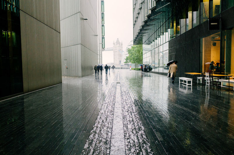 People walking between through vauxhall in the rain in london
