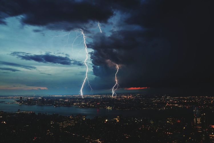 Lightning over city against sky at night
