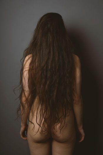 Midsection of woman standing against black background