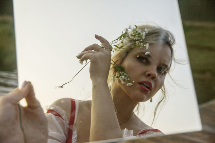 Portrait of woman holding plant