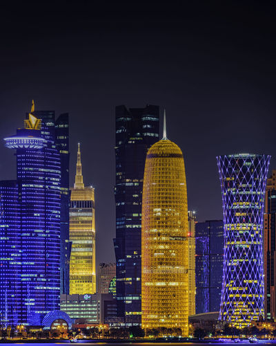 Illuminated buildings against sky at night