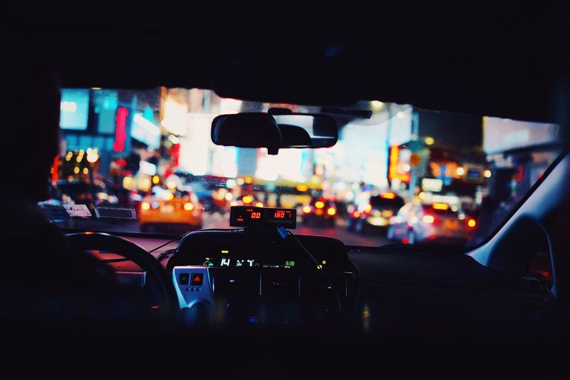 Close-up of car on illuminated city street at night