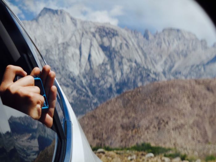 Close-up of hands photographing from car