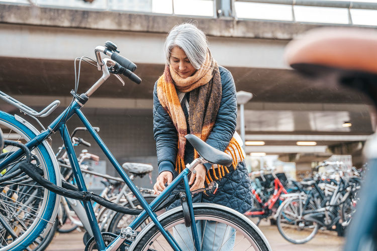 Mature woman renting bicycle at bicycle sharing system
