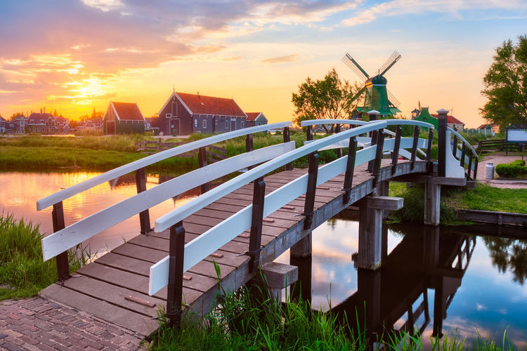 Bridge over river against sky during sunset