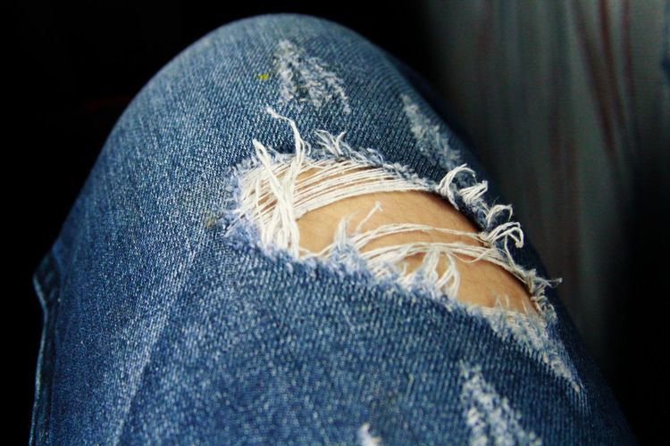 Cropped image of leg with torn jeans