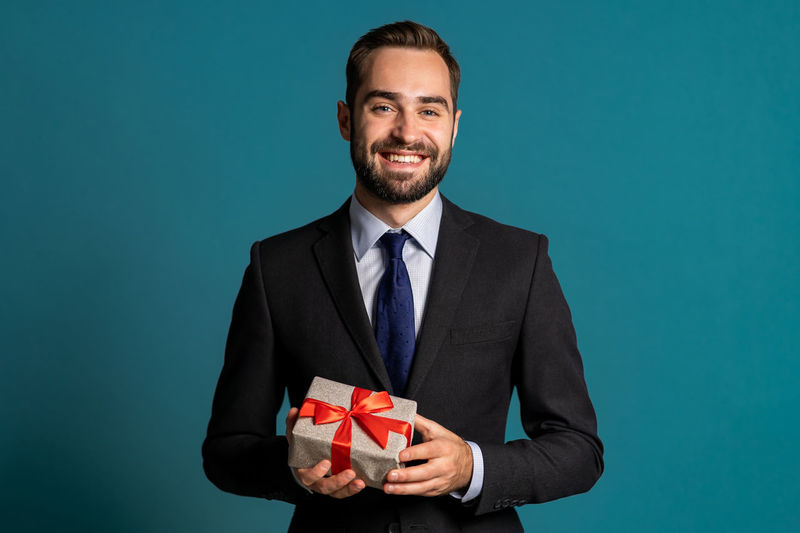 Portrait of a smiling young man against blue background