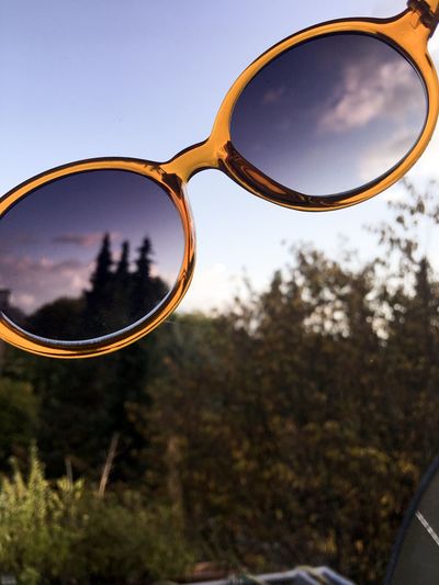 Close-up of sunglasses against sky