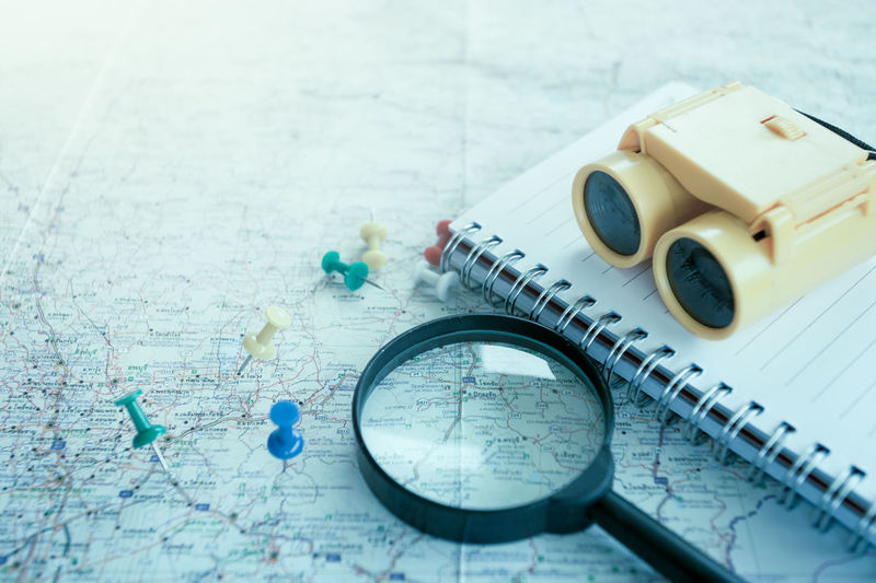 Close-up of binoculars and magnifying glass on map