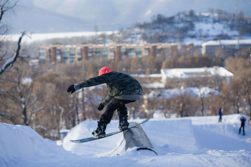 Man snowboarding on land against sky