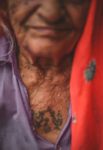 Mid section of senior adult woman with tattoo