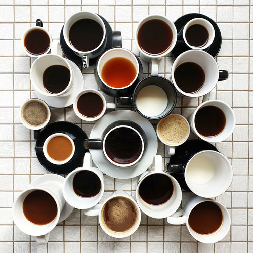 High angle view of multiple collection coffee cups on tiled table