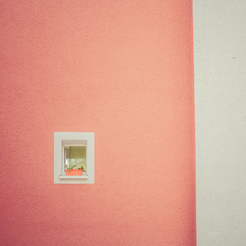 Low angle view of window on coral wall