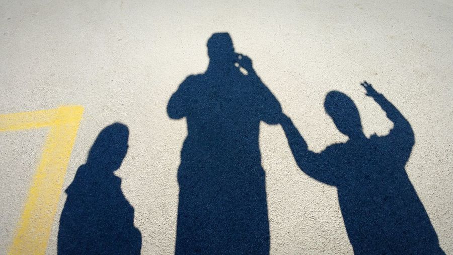 Shadow of friends standing on wall