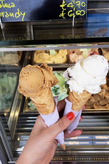 Close-up of hand holding ice cream cone at store
