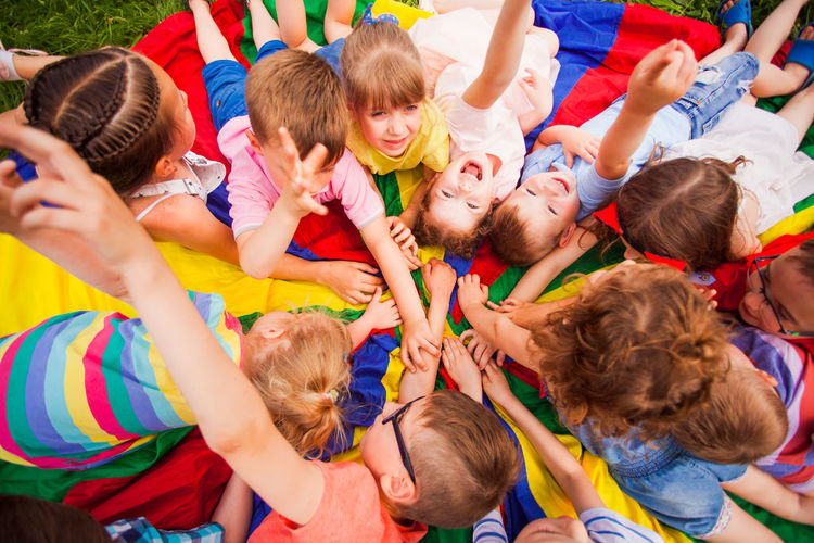 High angle view of kids stacking hands outdoors
