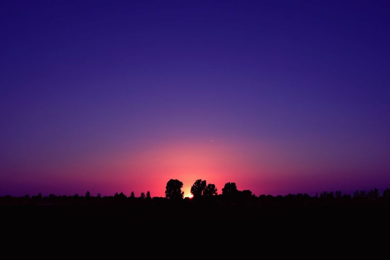 Silhouette landscape against sky at night