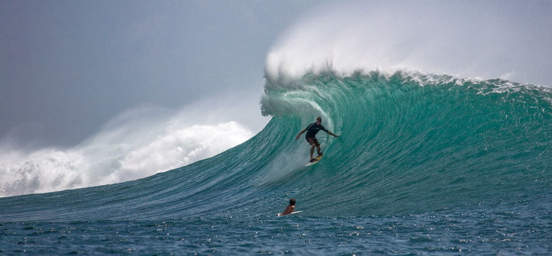 Man surfing in sea against sky