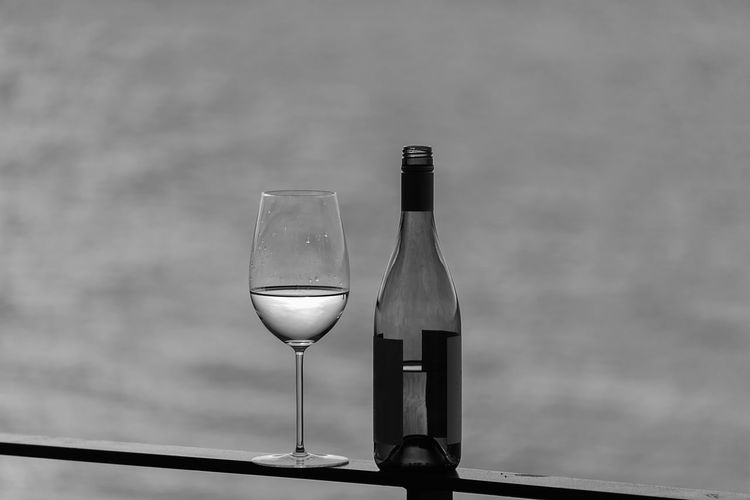Close-up of wineglass on table against sky