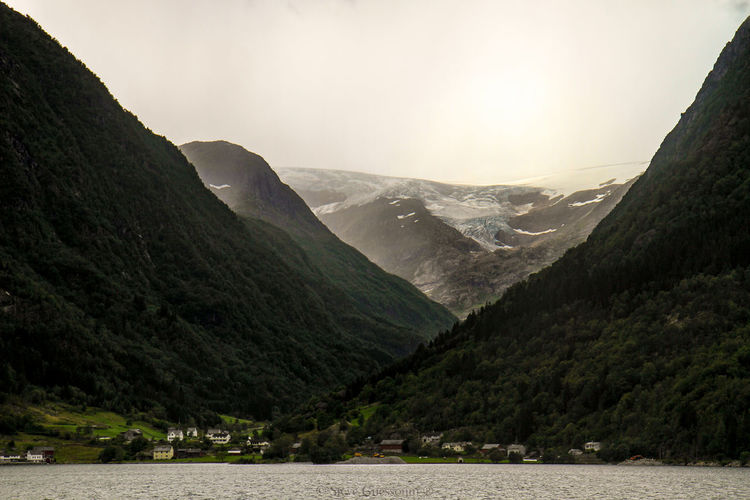 Scenic view of river and mountains against sky