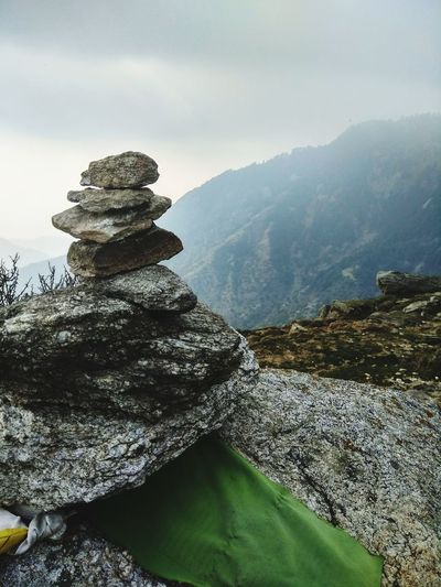 Stack of rocks on mountain against sky