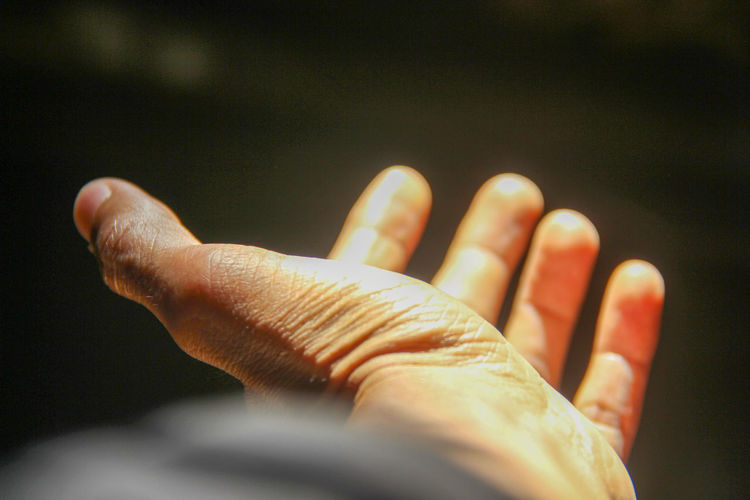Close-up of person hand against black background