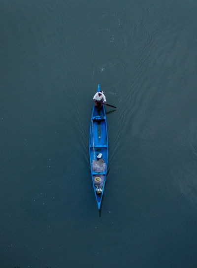 High angle view of man sitting in fishing boat on sea