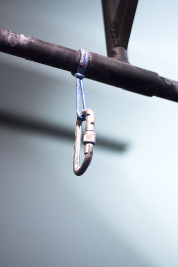 Low angle view of carabiner hanging on rod