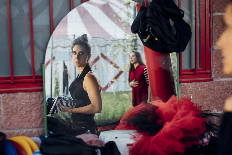 Reflection of female artists in mirror at circus tent