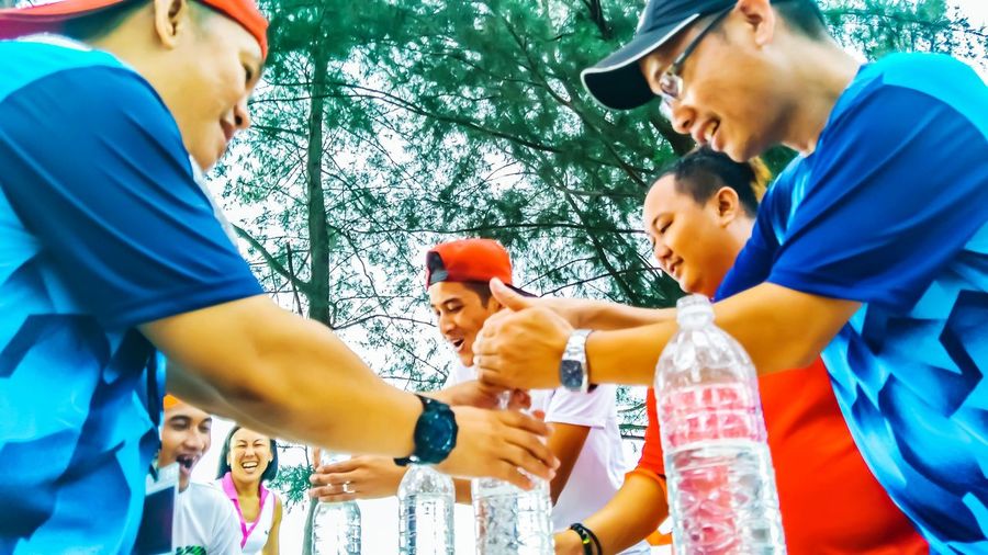Low angle view of men playing with water bottles
