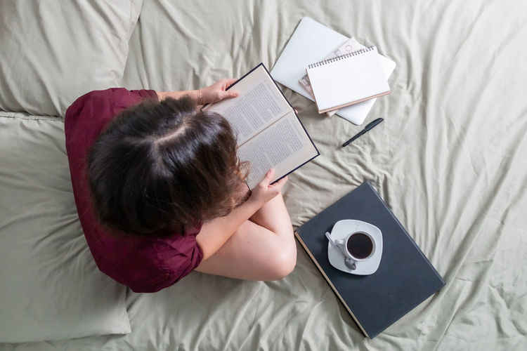 High angle view of woman lying on bed at home