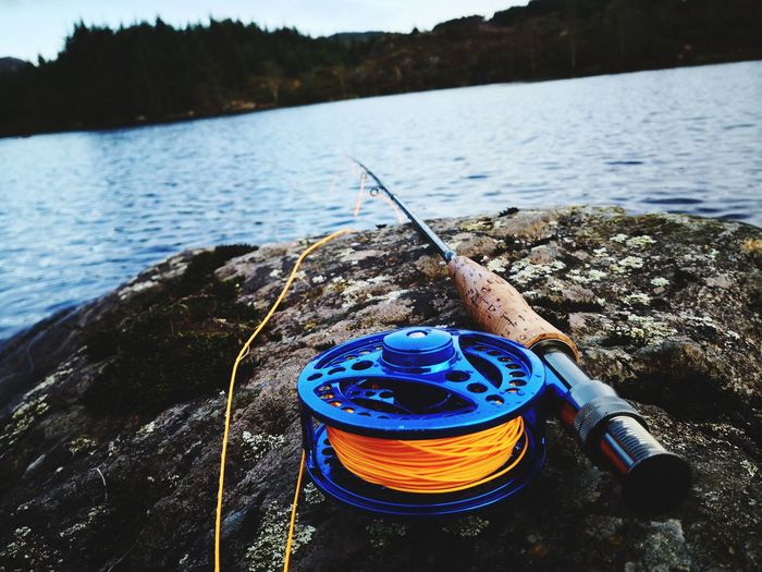 Fishing rod on rock by lake