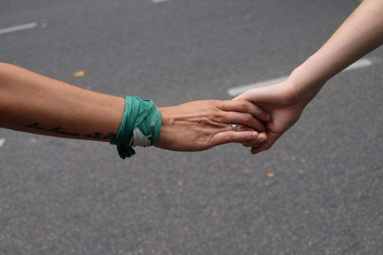 Midsection of couple holding hands on street