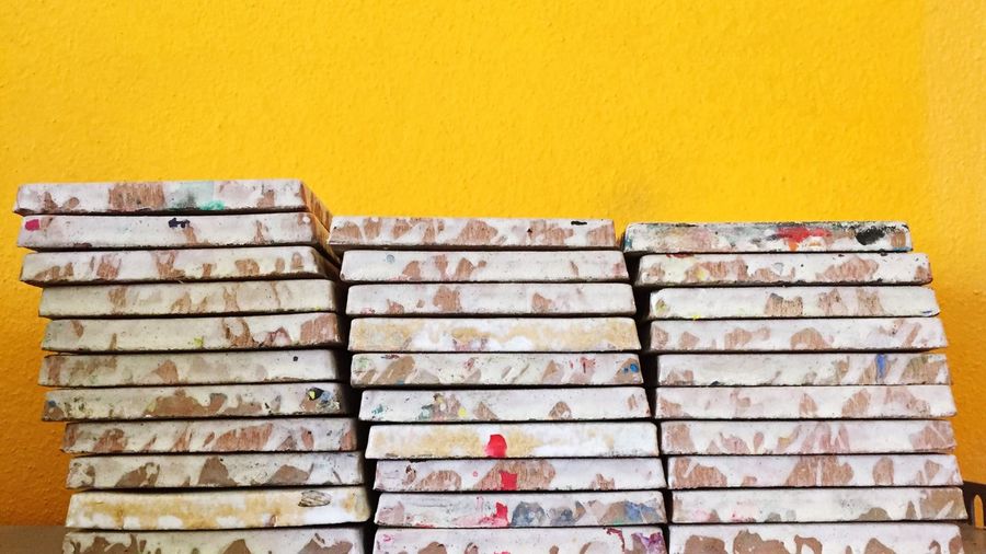 Stacked tiles against yellow wall