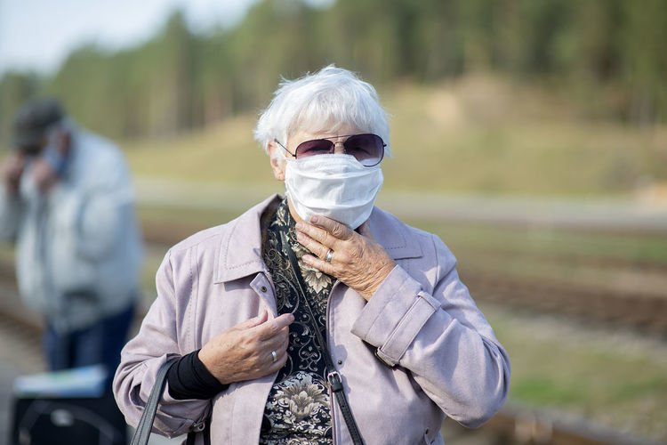 Portrait of senior woman with medical mask on face, prevention against viruses and infections