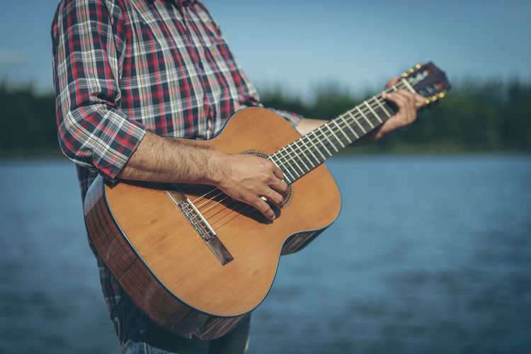 Man playing guitar on lake