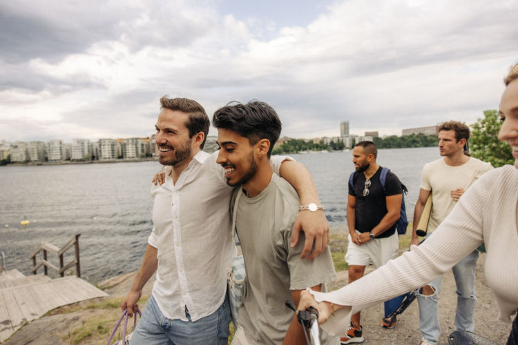 Group of friends standing by lake