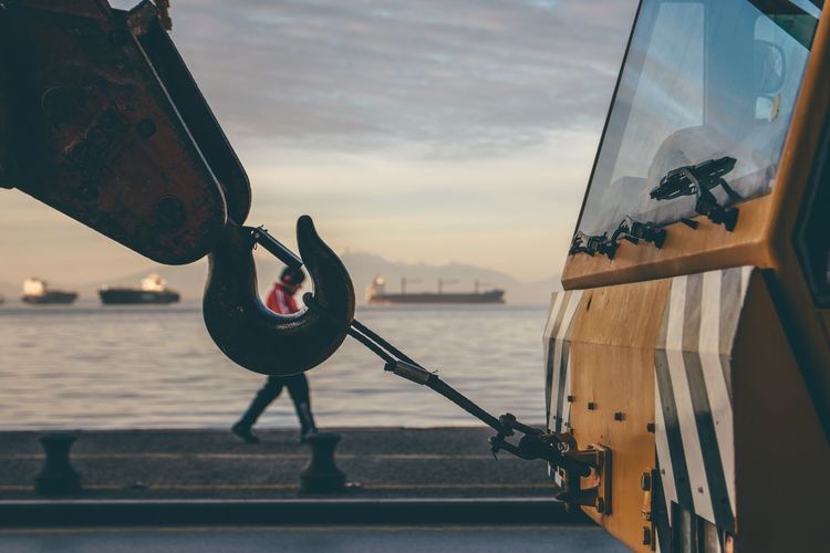 Close-up of construction vehicle with man walking in background