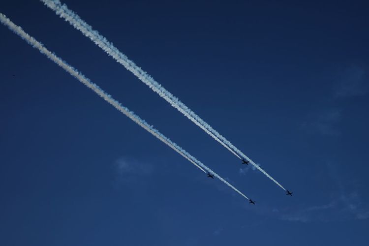Low angle view of airshow against blue sky