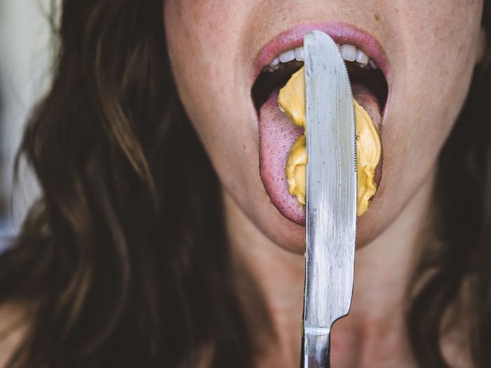 Close-up of woman licking peanut butter