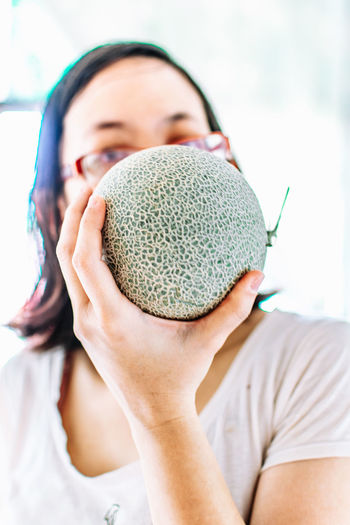 Close-up portrait of a woman holding melon