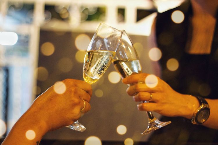 Cropped hands of friends toasting champagne flutes