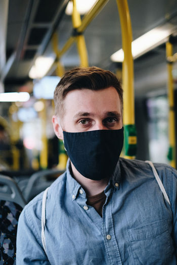 Portrait of man wearing mask in train