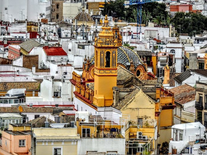 Rooftops in spain, yellow church mosque surrounded by white buildings cityscape