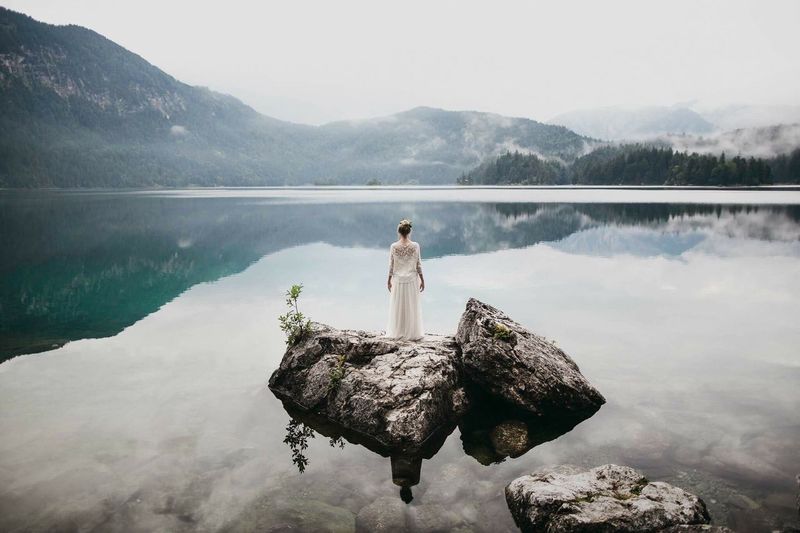 Woman in lake against mountains