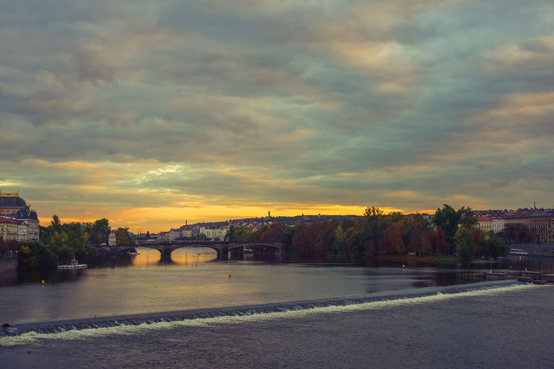 Bridge over river against sky during sunset