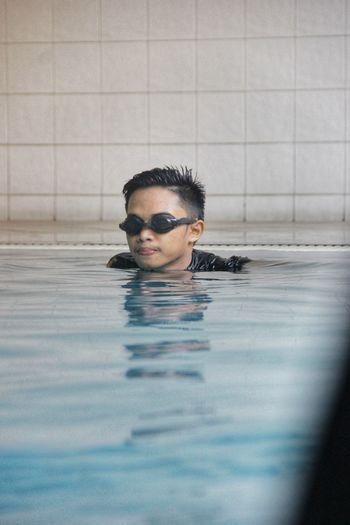 Portrait of young man swimming in pool